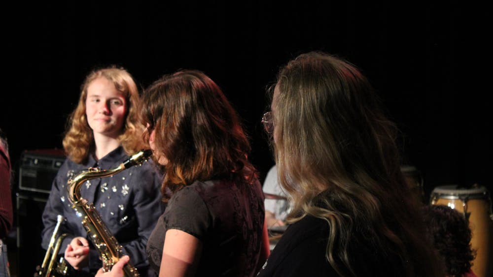 close up of girls on stage, one playing saxophone
