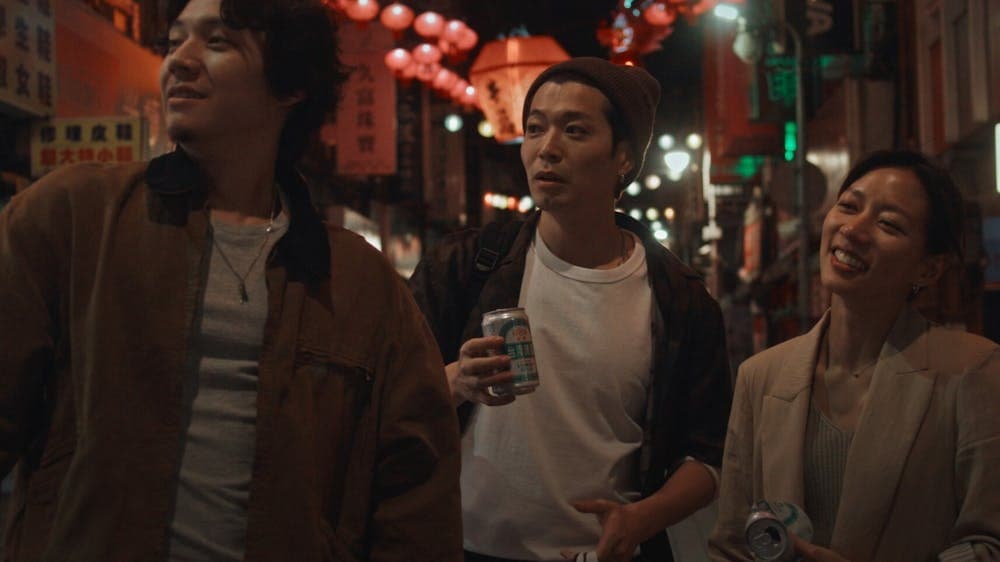 Three people walking in the streets of Taipei